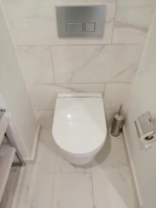 a white bathroom with a white toilet in a room at Subtropik Apartments in Batumi in Batumi
