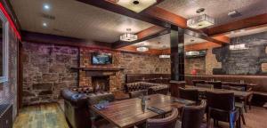 a restaurant with a table and chairs and a fireplace at Number 44 Hotel & Bar in Stonehaven