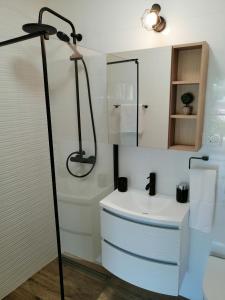 uma casa de banho com um chuveiro e um lavatório branco em Apartments Iris em Marina