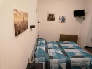 - une chambre avec un lit et des photos sur le mur dans l'établissement Hotel Centrale, à Cascia