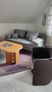 ein Wohnzimmer mit einem Sofa und einem Tisch in der Unterkunft Ferienwohnung Kalltalblick in Simmerath