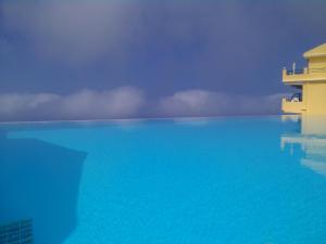 a pool of blue water next to a building at Fantastico Studios #2 in Kalamitsi