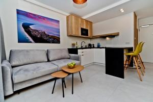 uma sala de estar e cozinha com um sofá e uma mesa em BlueApart Apartland Residence em Jastarnia