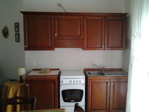 a kitchen with wooden cabinets and a white stove top oven at Rubens in Alghero