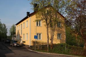 a yellow house with a car parked in front of it at Casino Islands Getaway in Savonlinna