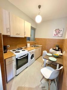 a kitchen with a stove and a table with chairs at Melenia Suites in Rhodes Town