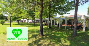 a sign that says we open space in a park at Grand Hotel Esplanada in Bibione