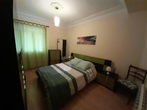 een slaapkamer met een bed met een gestreepte sprei bij APARTAMENTO BAHÍA DE SANTANDER in Santander