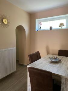 a dining room with a table and chairs and a window at Vir&aacute;g Vend&eacute;gh&aacute;z in Poroszl&oacute;