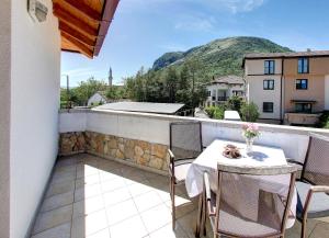 patio con mesa y sillas en el balcón en Hotel Almira, en Mostar