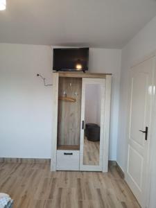 Dieses weiße Zimmer verfügt über eine Tür und einen TV an der Decke. in der Unterkunft CASA BIA CRIBO Sannicolau de Munte - bai termale in Săcueni