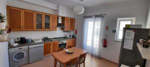 cocina con mesa, fregadero y lavavajillas en CasAzulApartments en Sintra