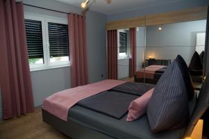 - une chambre avec 2 lits et un miroir dans l'établissement Schöner Wohnen, à Friesenheim