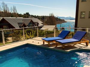 duas cadeiras azuis sentadas ao lado de uma piscina em Quintaluna Piscina, Playa y Montaña em San Carlos de Bariloche