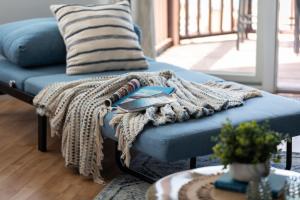 un sofá azul con una manta en la sala de estar en New Listing Beach Bliss 211! Stunning bay view en Traverse City