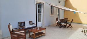 a patio with chairs and a table and a couch at CasAzulApartments in Sintra