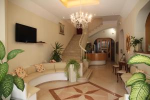 a living room with a couch and a chandelier at Hotel Adriatica sul Mare in Rimini