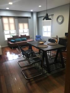 a living room with a table and chairs and a couch at ÁGORA LUX in Ourense