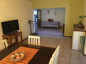 een woonkamer met een eettafel en een televisie bij Casa cerca del centro Bed&breakfast in Mendoza