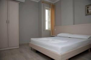 a bedroom with a white bed and a window at Hotel Vila Lule in Durrës