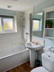 Chalet 23 Widemouth Bay في بود: حمام مع حوض وحوض استحمام ومرحاض