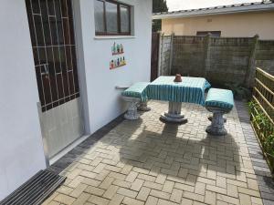 una mesa y dos bancos en un patio en GlassTree B&B, en Bredasdorp