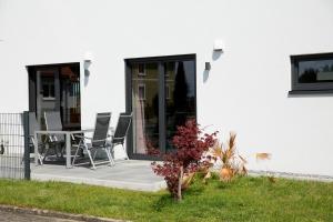 Cette maison blanche dispose d'une terrasse avec une table et des chaises. dans l'établissement Schöner Wohnen, à Friesenheim