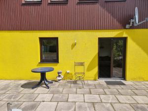 un edificio amarillo con una mesa y una silla en Yellow House en Osnabrück
