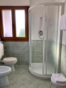 La salle de bains est pourvue d'une douche et de toilettes. dans l'établissement Hotel Serena, à Grado