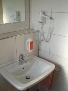 a bathroom with a white sink and a phone at Gasthof Zur frohen Einkehr in Reichardsroth +37 photos