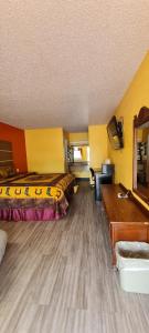 Habitación de hotel con 2 camas y escritorio en Chaparral Motel Hallettsville, en Hallettsville
