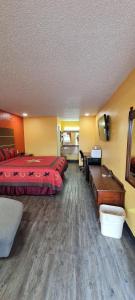 Habitación de hotel con 2 camas y escritorio en Chaparral Motel Hallettsville, en Hallettsville