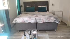 ein Schlafzimmer mit einem großen Bett mit grünen Kissen in der Unterkunft Slatka Tajna in Banja Luka