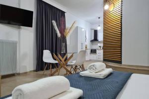 salon z łóżkiem, stołem i krzesłami w obiekcie Apartment in the heart of the city 4 w mieście Larisa