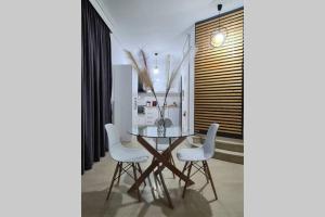 a dining room with a glass table and white chairs at Apartment in the heart of the city 4 in Larisa