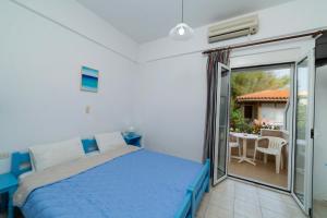 a bedroom with a bed and a balcony with a table at La Stella Apartments in Amoudara Herakliou