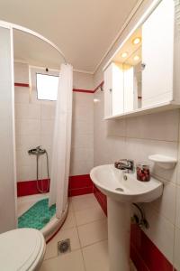 een badkamer met een wastafel, een douche en een toilet bij La Stella Apartments in Amoudara Herakliou