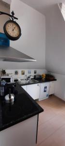 a kitchen with a clock hanging on the wall at CasAzulApartments in Sintra