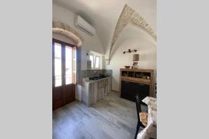 a kitchen with a wooden door and a counter top at Un Cuore e Due Capanne in Ceglie Messapica +8 photos