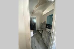 a bathroom with a sink and a toilet and a mirror at Un Cuore e Due Capanne in Ceglie Messapica