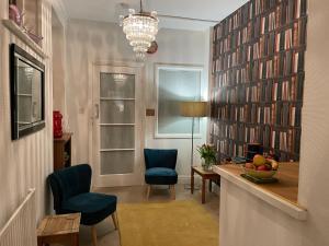 a living room with a table and chairs and books at G&T Apartment in Scarborough