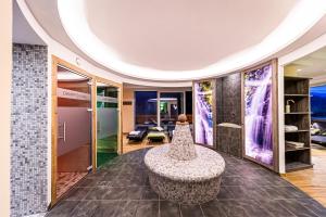 a lobby with a circular table and a room with glass doors at Landhotel Timmerer in Möderbrugg