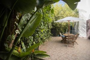 a patio with a table and an umbrella at Villa Margherita in Canicattini Bagni
