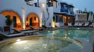 阿喬普羅柯皮歐斯的住宿－迪米特拉公寓式酒店，庭院中带椅子的游泳池和大楼