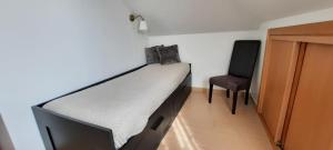 a bedroom with a bed and a chair in it at CasAzulApartments in Sintra