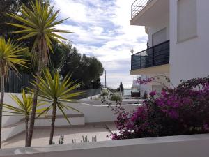 a view of a building with palm trees and flowers at Clube Meia Praia in Lagos