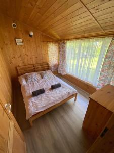 a small bedroom with a bed in a wooden cabin at Przystanek Kaszuby in Łeba