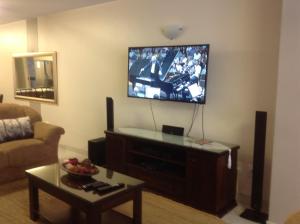 uma sala de estar com uma televisão de ecrã plano na parede em Sand & Sea Holiday Home em Swakopmund