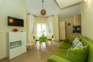 salon z zieloną kanapą i stołem w obiekcie Apartments La Mirage w mieście Pirovac