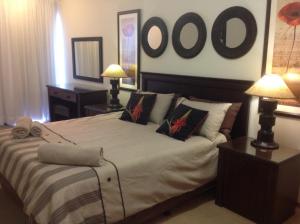 a bedroom with a large bed with two lamps at Sand & Sea Holiday Home in Swakopmund